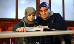 Çevresini silüet olarak gören kadın, yediden yetmişe Kur'an-ı Kerim öğretiyor