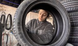 Sahada top koşturan genç kız, oto lastik dükkanında da babasına yardımcı oluyor